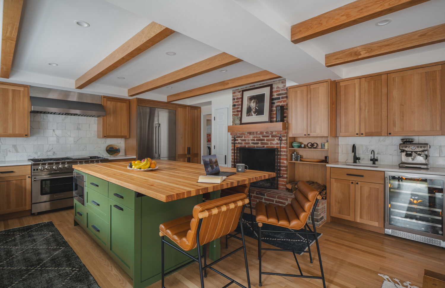 Hammer's 2024 kitchen masterpiece featuring modern wooden cabinetry, a stylish green island, and exposed beams, blending natural aesthetics with contemporary design.